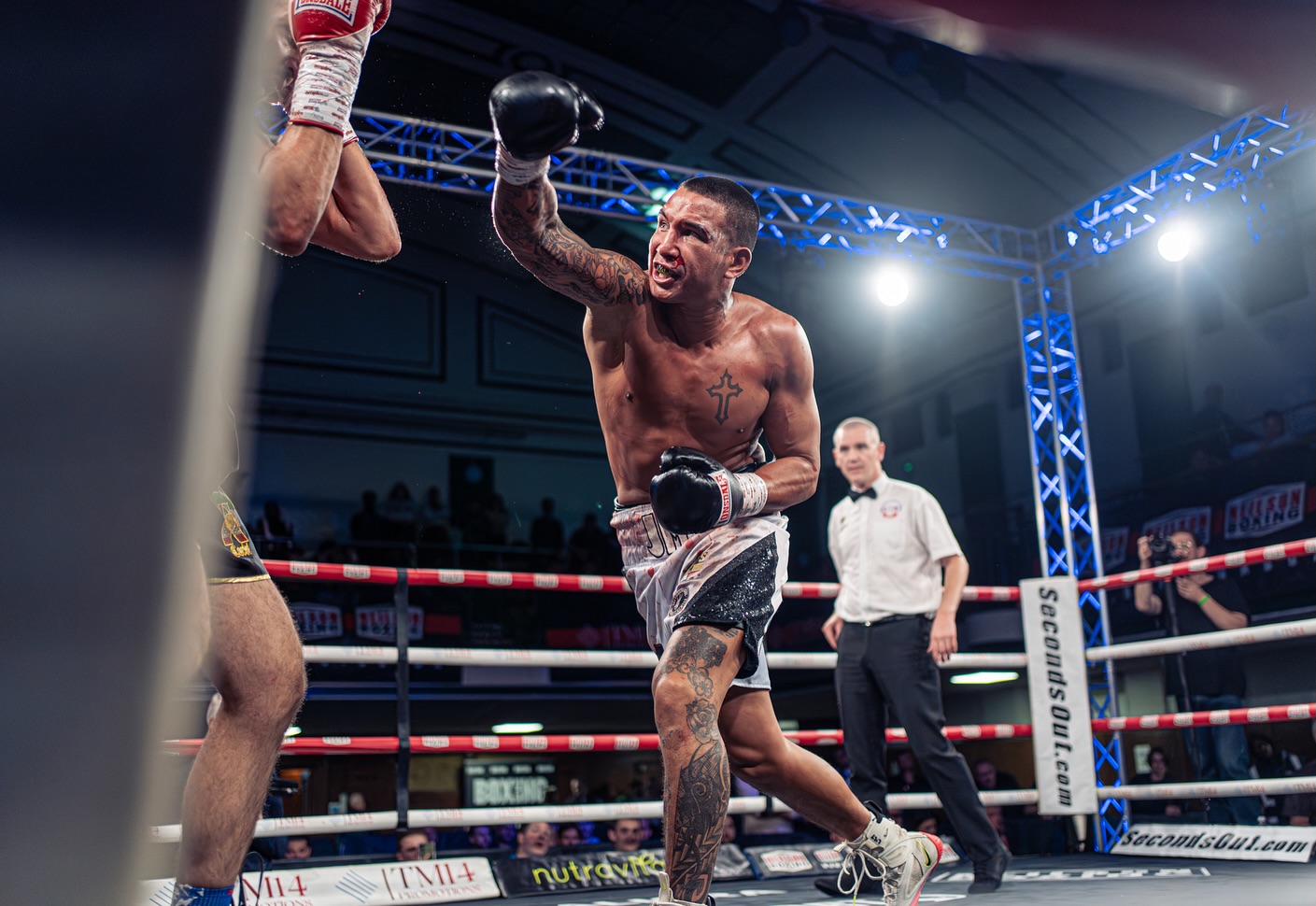 Boxer mid-punch under stage lighting