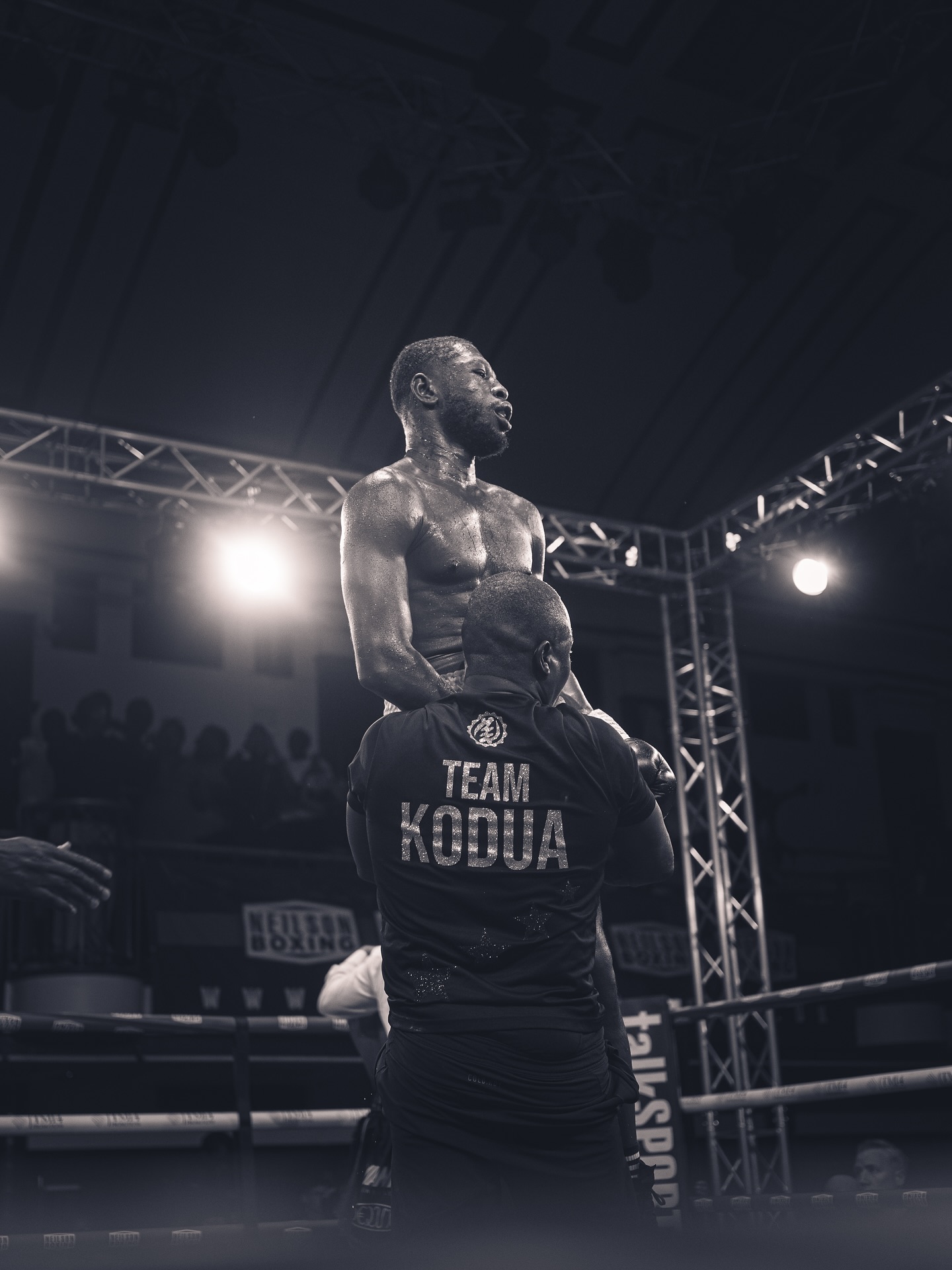Boxer standing over opponent, dramatic ring lighting